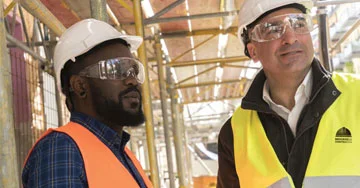 two people in safety vests talking