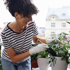 Woman using gardent tools with a potted plant