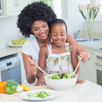 Two people cooking in a kitchen with large bowls