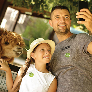 Dad and daughter taking a picture at the zoo