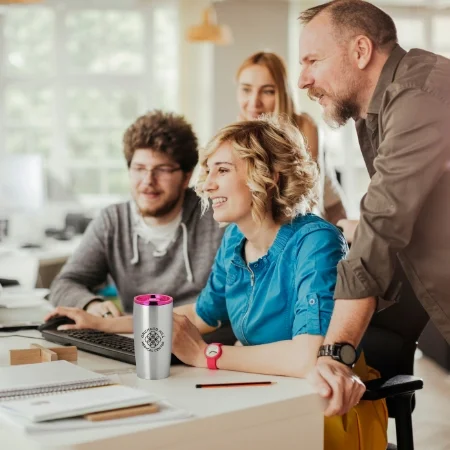 Team of workers around a computer at the office.