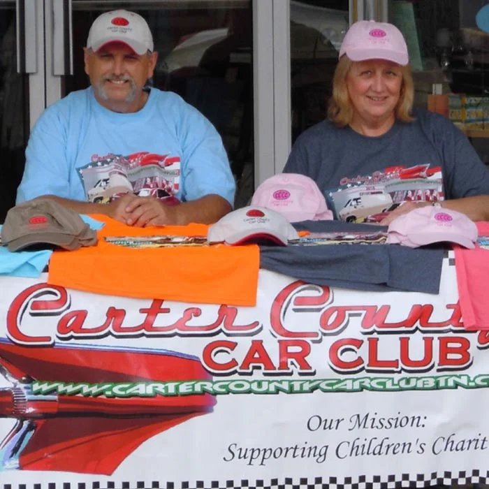 People at table at a car show