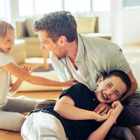 Man laughing with a group of kids