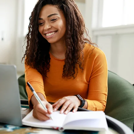 Woman at a computer taking notes