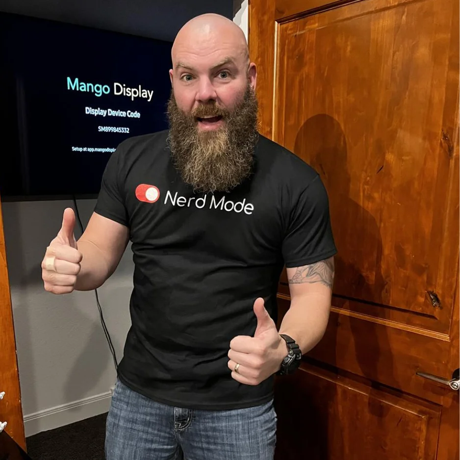 person giving a thumbs up wearing a printed t shirt