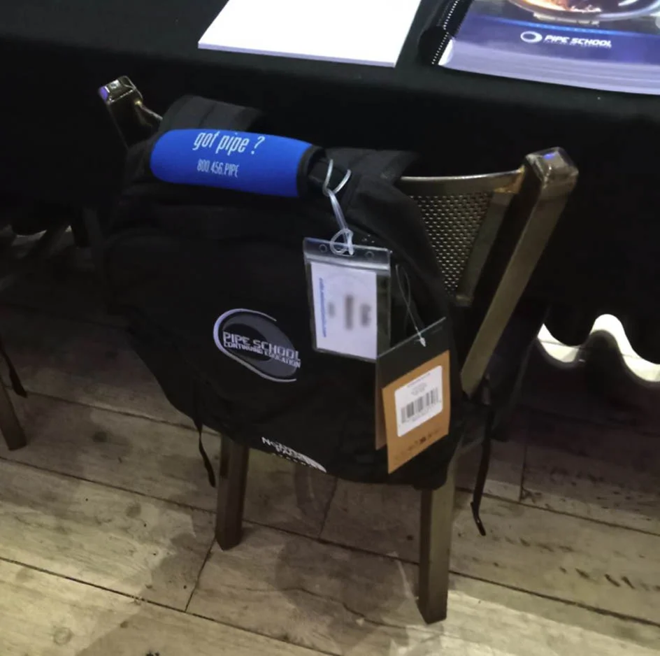 logoed bag hooked on the back of a chair