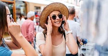A woman trying on sunglasses in a crowd