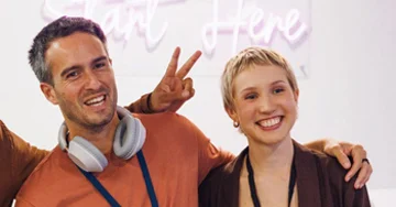 two people smiling at a group event
