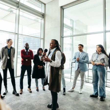 Team leader standing in the middle of a circle of people during a team building exercise at a staff retreat.