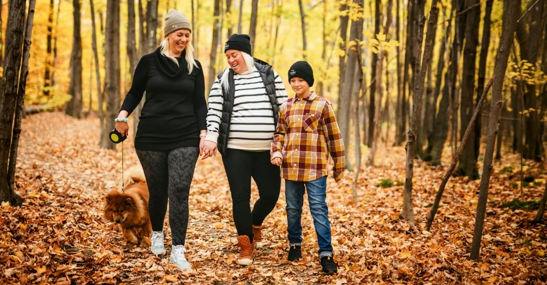Family walking in the woods during the fall season.