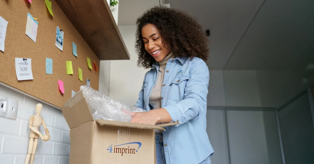 Smiling person opening a 4imprint package