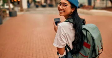 Woman walking through streets with a backpack