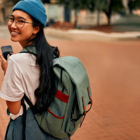 Woman walking through streets with a backpack