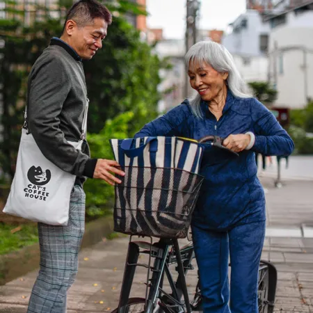 Man and woman walking on the sidewalk with cotton totes