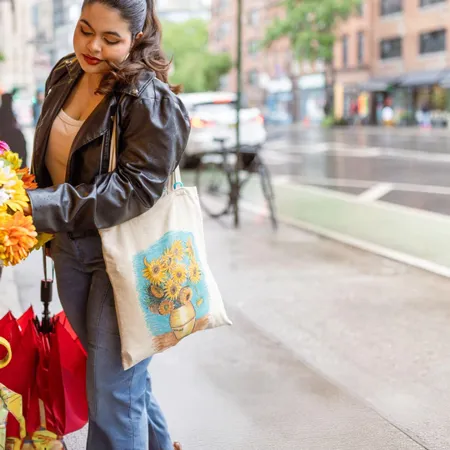 Woman shopping with reusable shopping tote carrying flowers and an umbrella