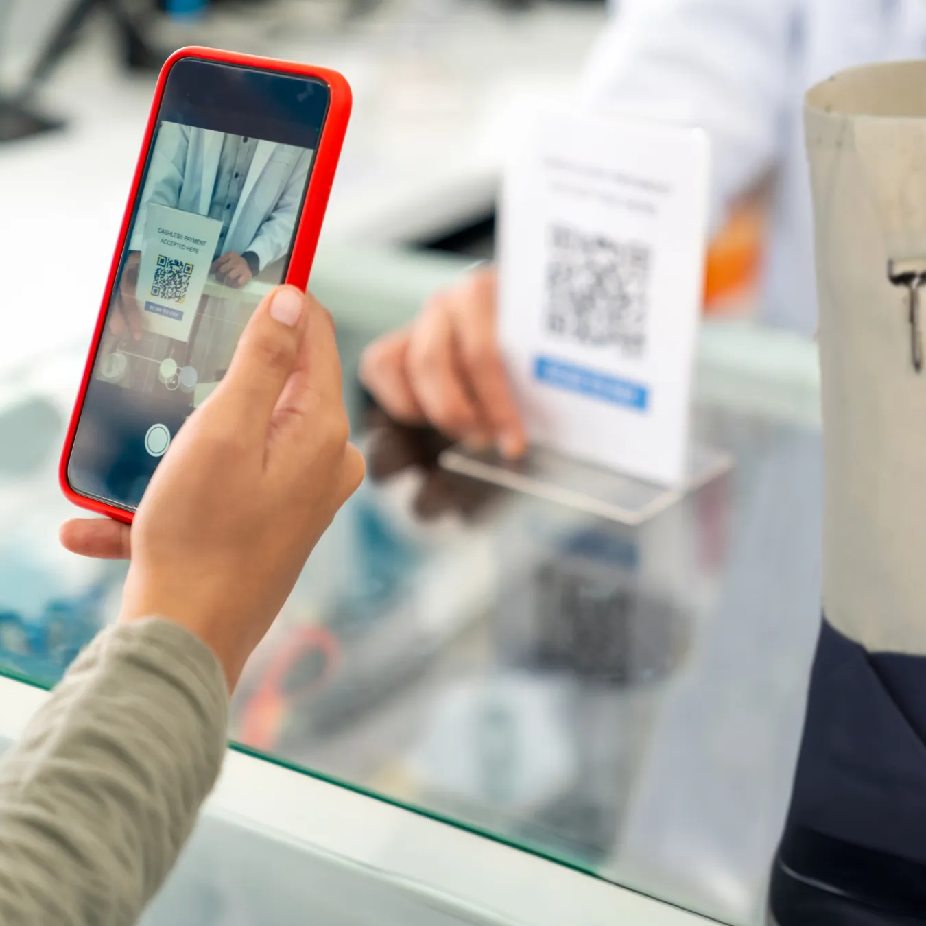 Person using phone to scan QR code on tabletop display.