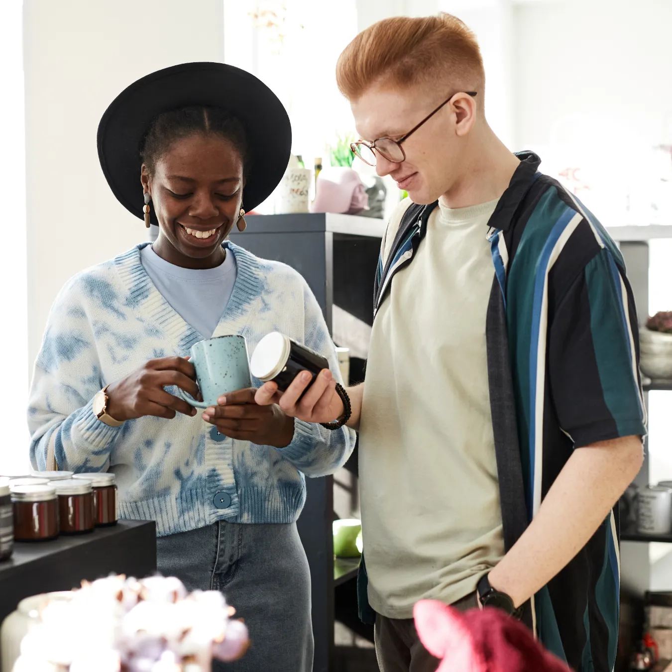 Two smiling young people looking for good deals in a store.