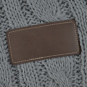 Additional Image 3 - a brown leather label on a grey knitted surface