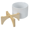 a white cup with a wooden stand