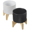 a black and white pot on wooden legs