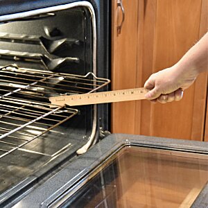Additional Image 3 - a person holding a wooden spatula in front of an oven