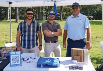 group of people standing by a sponsorship table