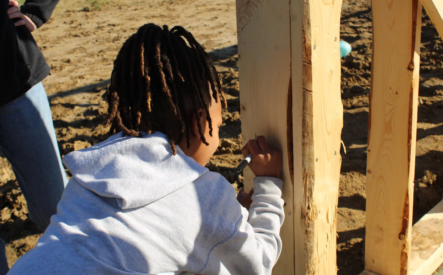 child drawing on a piece of wood