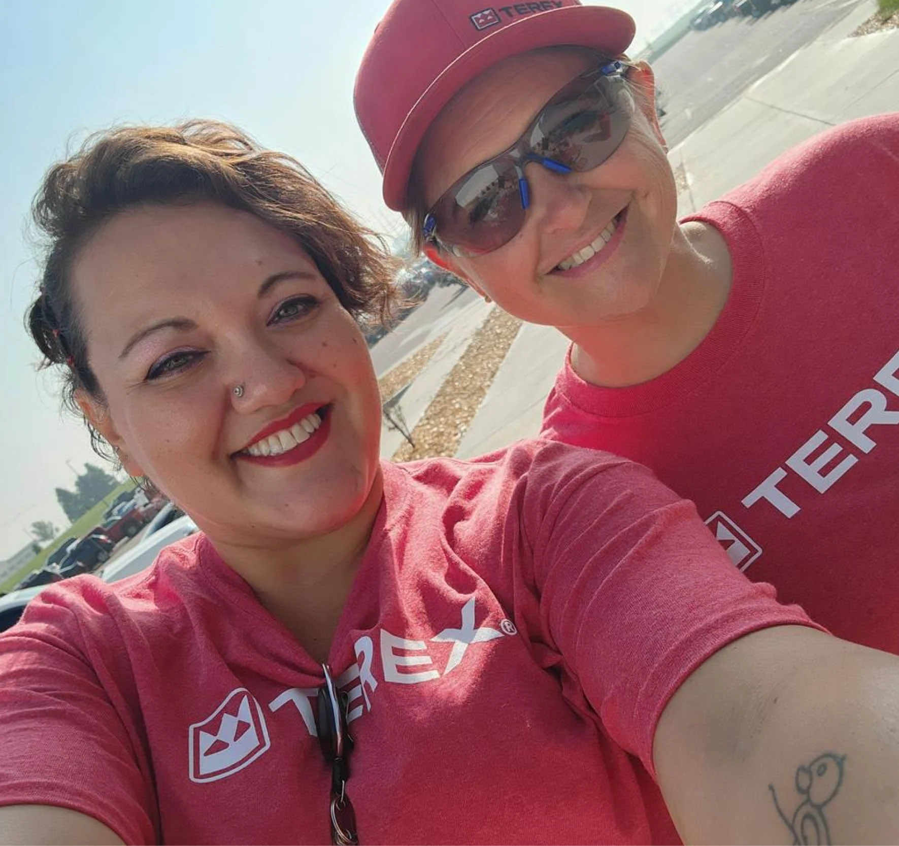 two people taking a selfie wearing logoed t shirts