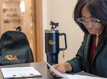 person standing next to promotional products including a tumber and backpack