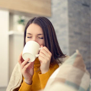 person drinking out of a ceramic mug