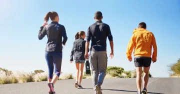 Group of people out for a walk on the road during the day.