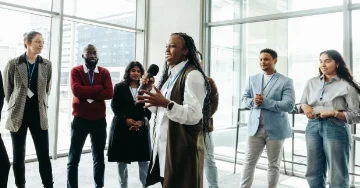 Team leader standing in the middle of a circle of people during a team building exercise at a staff retreat. 