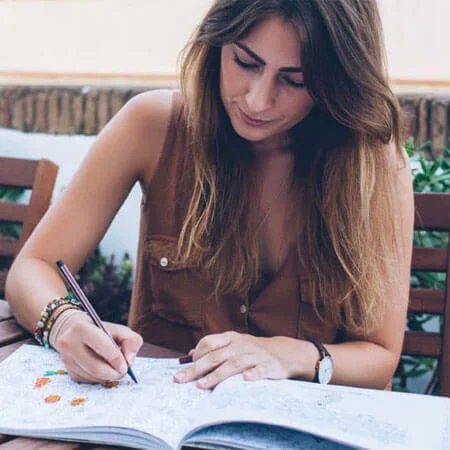 person coloring in a coloring book