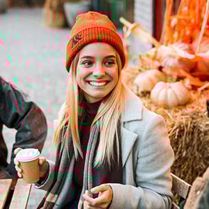 Woman drinking coffee while wearing a Carhartt beanie