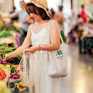 Woman shopping at a market with a reusable bag