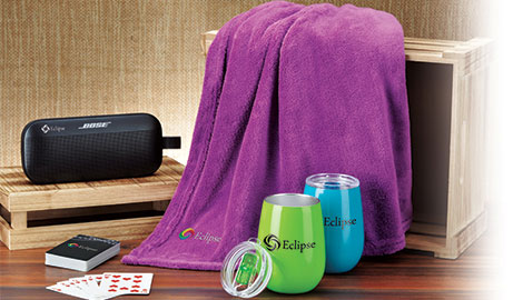 Business Gifts that includes a wireless speaker, blanket, tumbler and playing cards