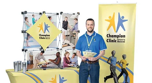 Promotional trade show items that include a vertical banner, display and table throw