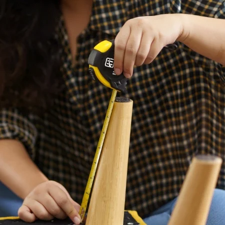 Person measuring a chair leg with a branded tape measure.