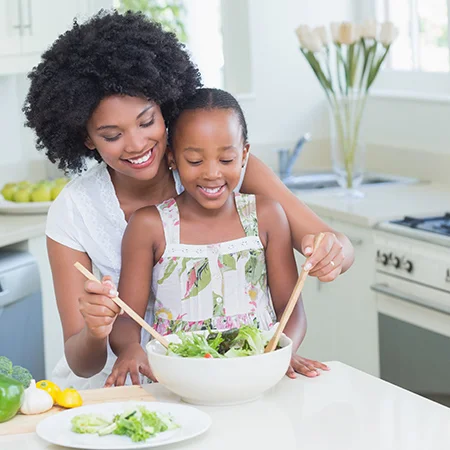 Two women cooking in a kitchen with a reusable kitchen bowls