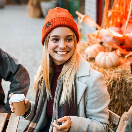 Woman drinking coffee with Carhartt beanie
