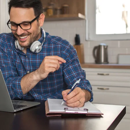 Man writing in a journal with a gel pen