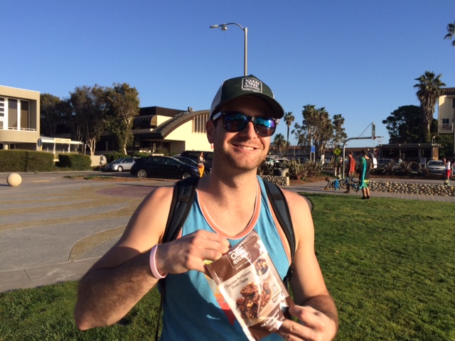 Customer photo from Christopher of our Mesh Back Trucker Cap - Embroidered, a man holding a bag of food