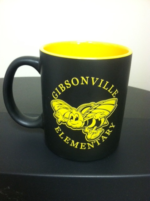 a black and yellow coffee mug
