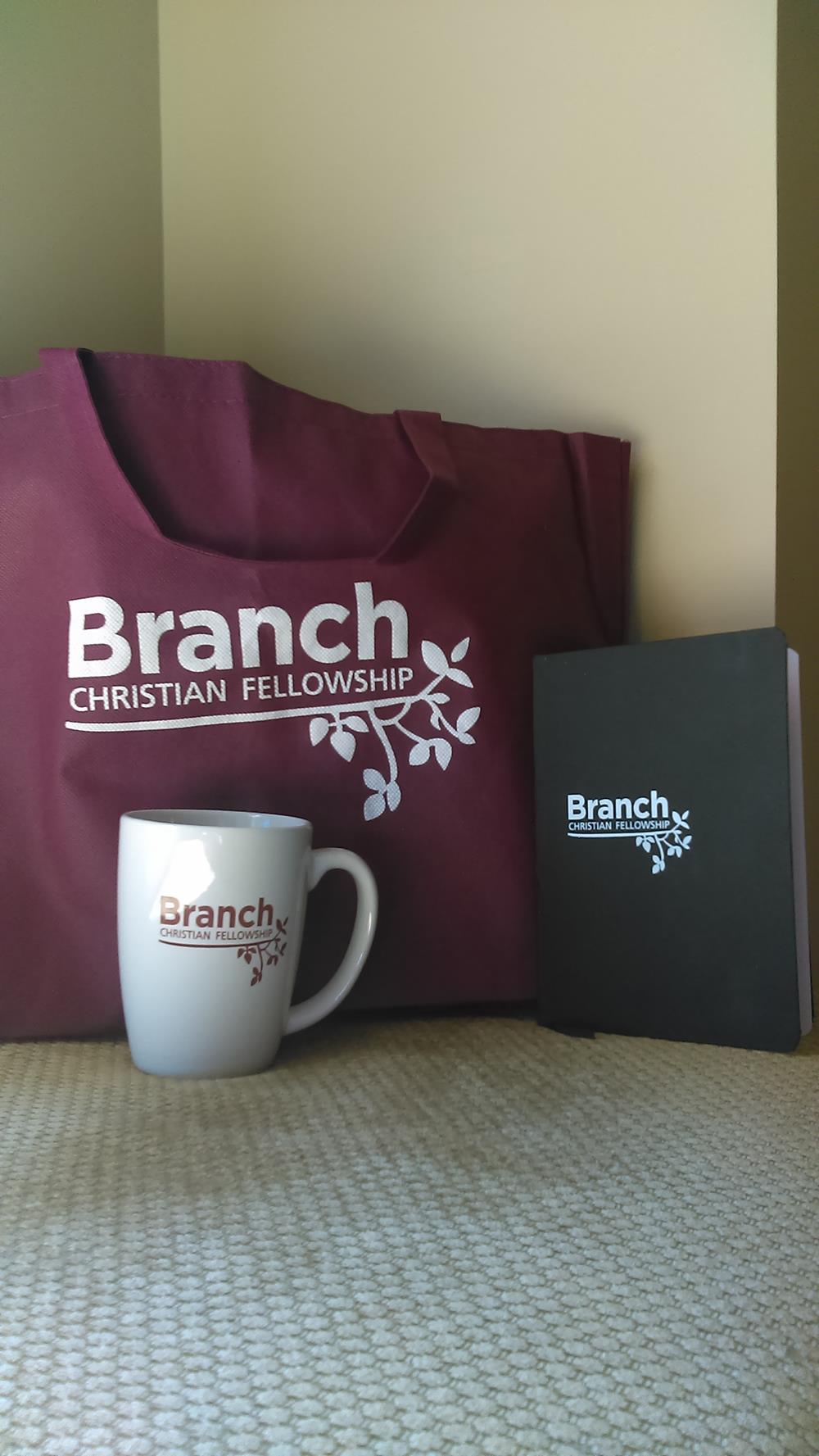 Customer photo from Susan of our Challenger Coffee Mug - White - 11 oz., a mug and book next to a bag