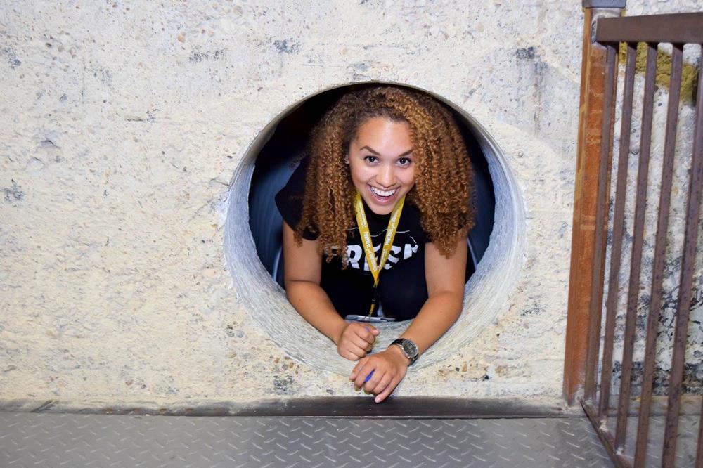 Customer photo from Lane of our Hang In There Lanyard - 40" - 24 hr, a woman smiling in a hole in a wall