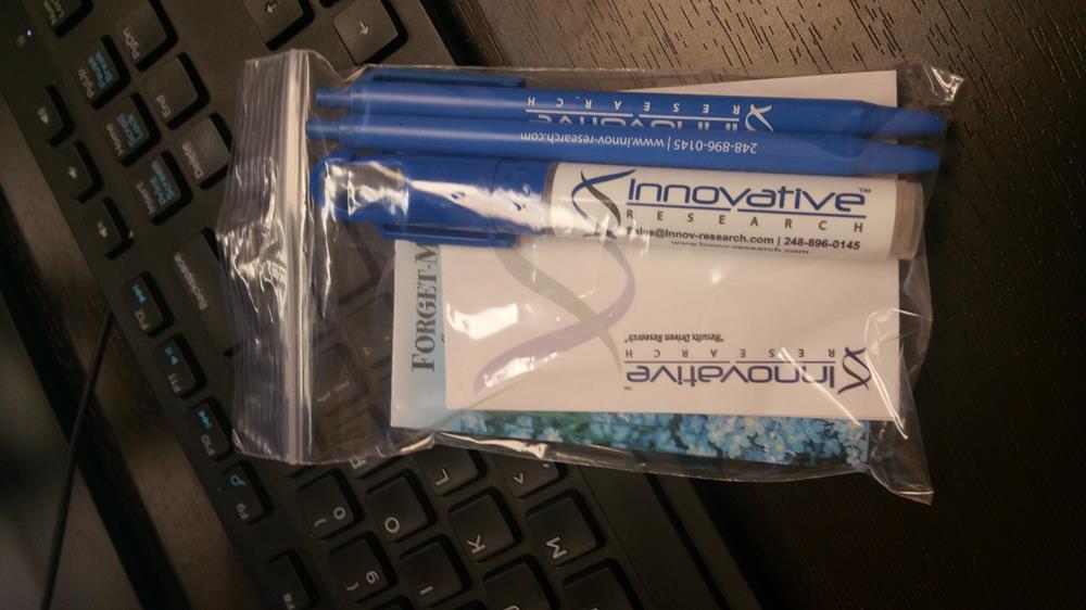 a blue pen in a plastic bag next to a keyboard