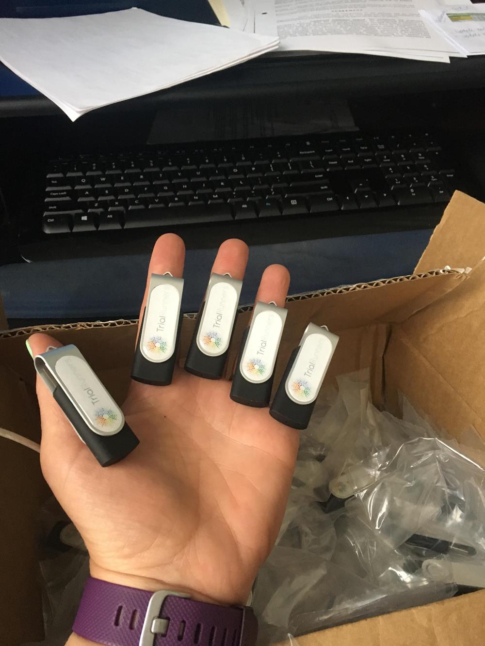 a hand holding several usb drives
