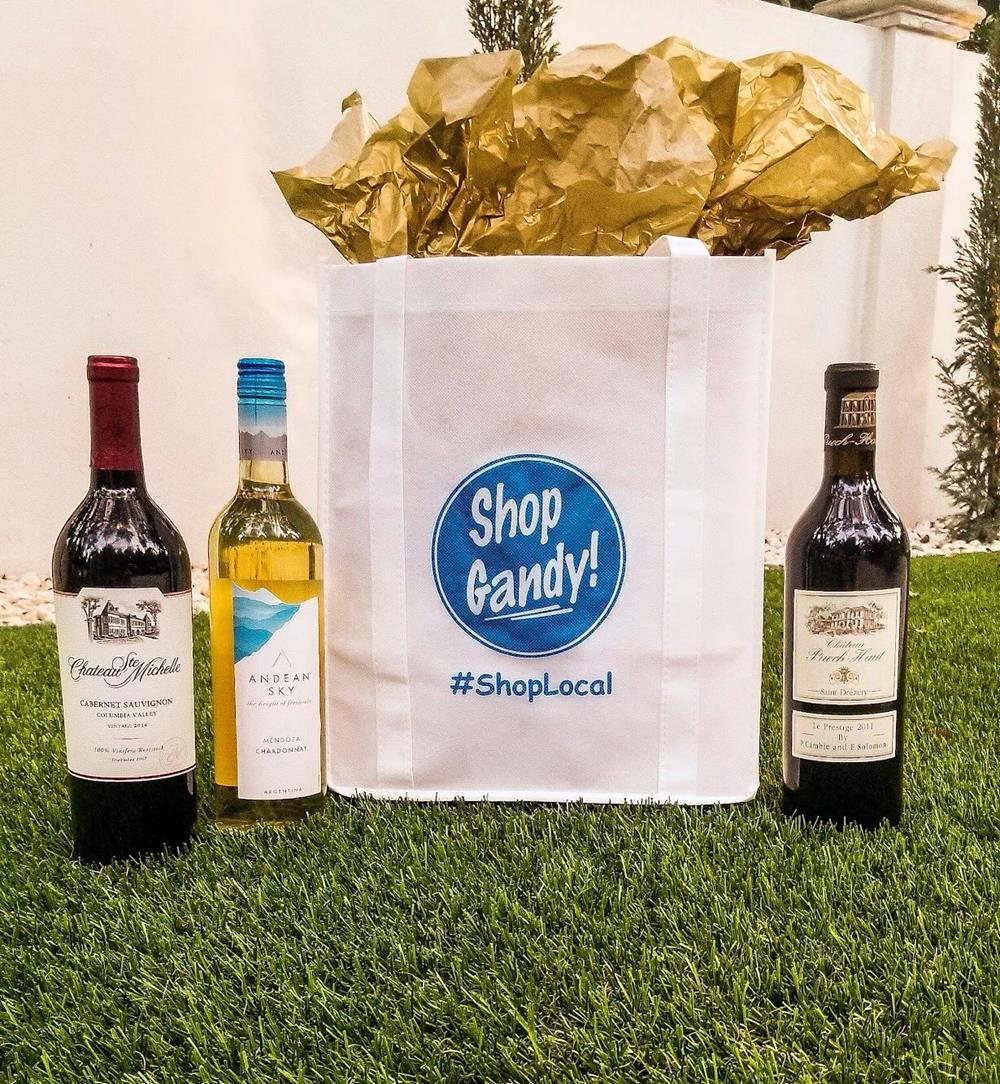 Customer photo from Sally of our Value Grocery Tote - 13 inches x 12 inches, a white bag with bottles of wine and a gold wrapped bag