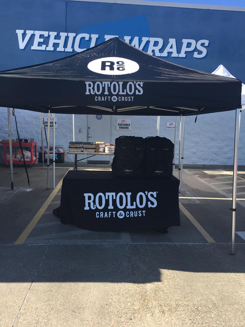 Customer photo from Brooke of our Serged Closed-Back Table Throw - 8 feet, a tent with a black cover and white text