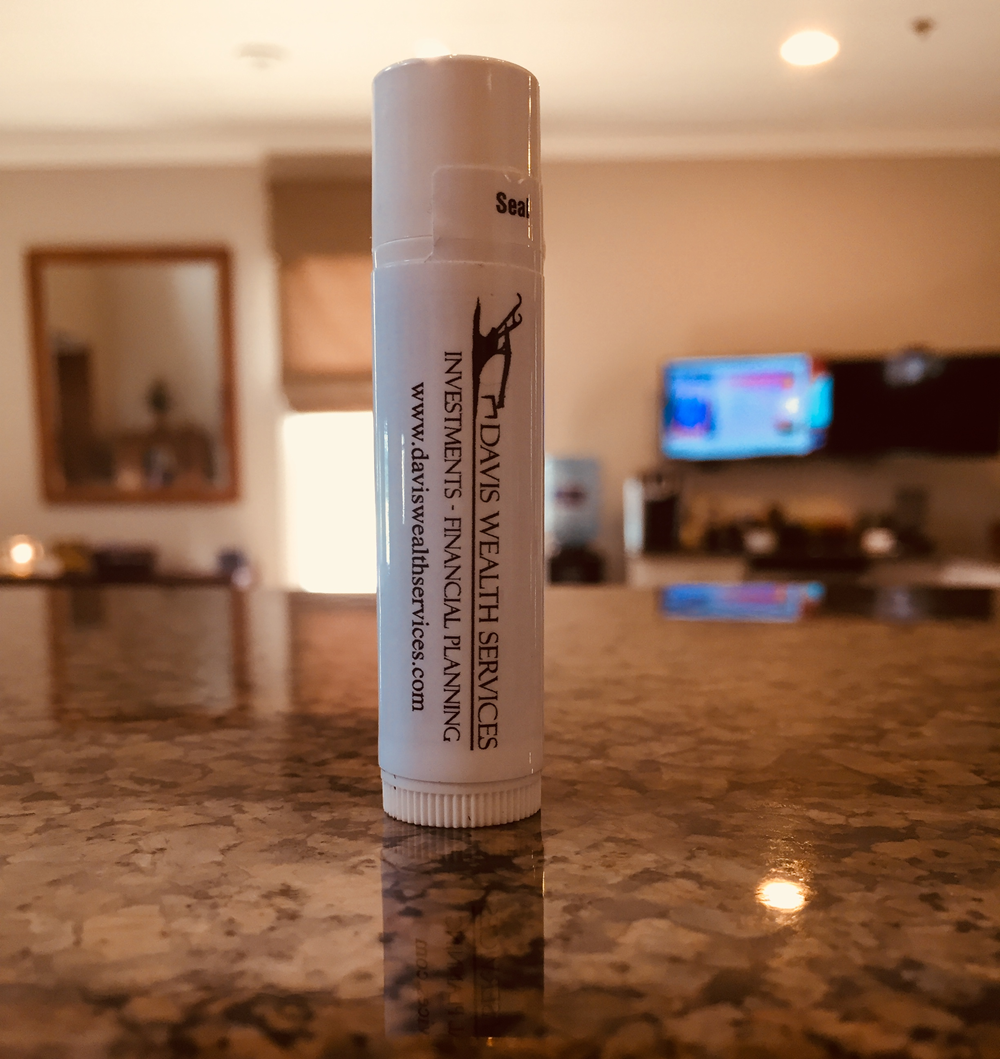 Customer photo from Chad of our Value Lip Balm, a white tube on a marble counter